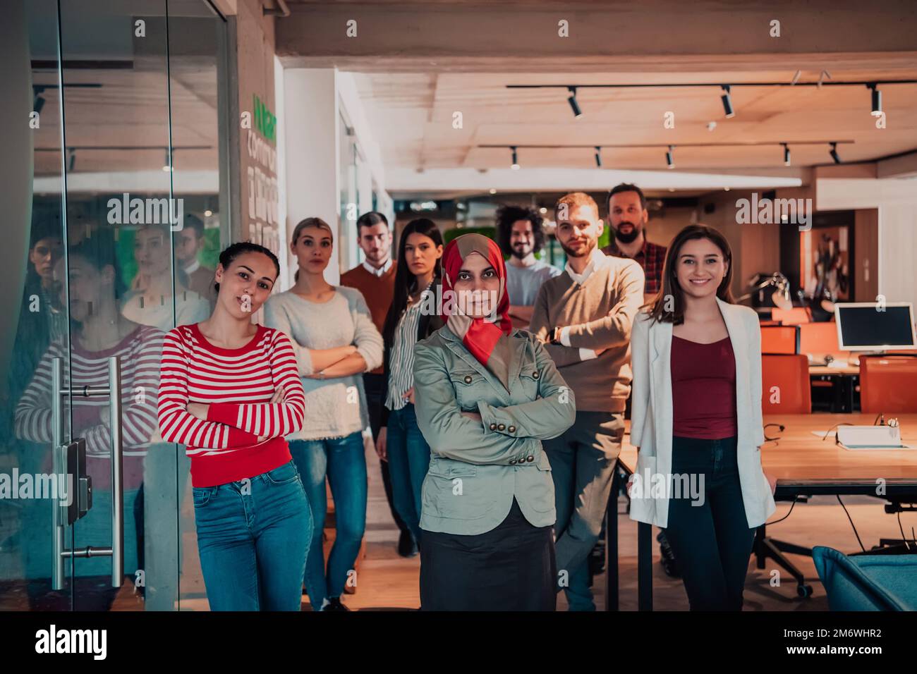 A diverse group of successful business people in a modern glass office ...