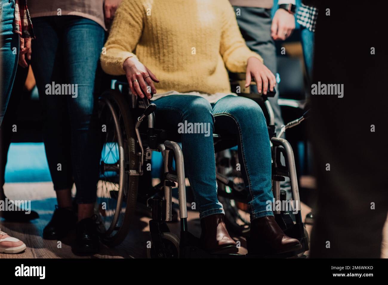Close up photo of a woman with a disability sitting in a wheelchair in the office Stock Photo