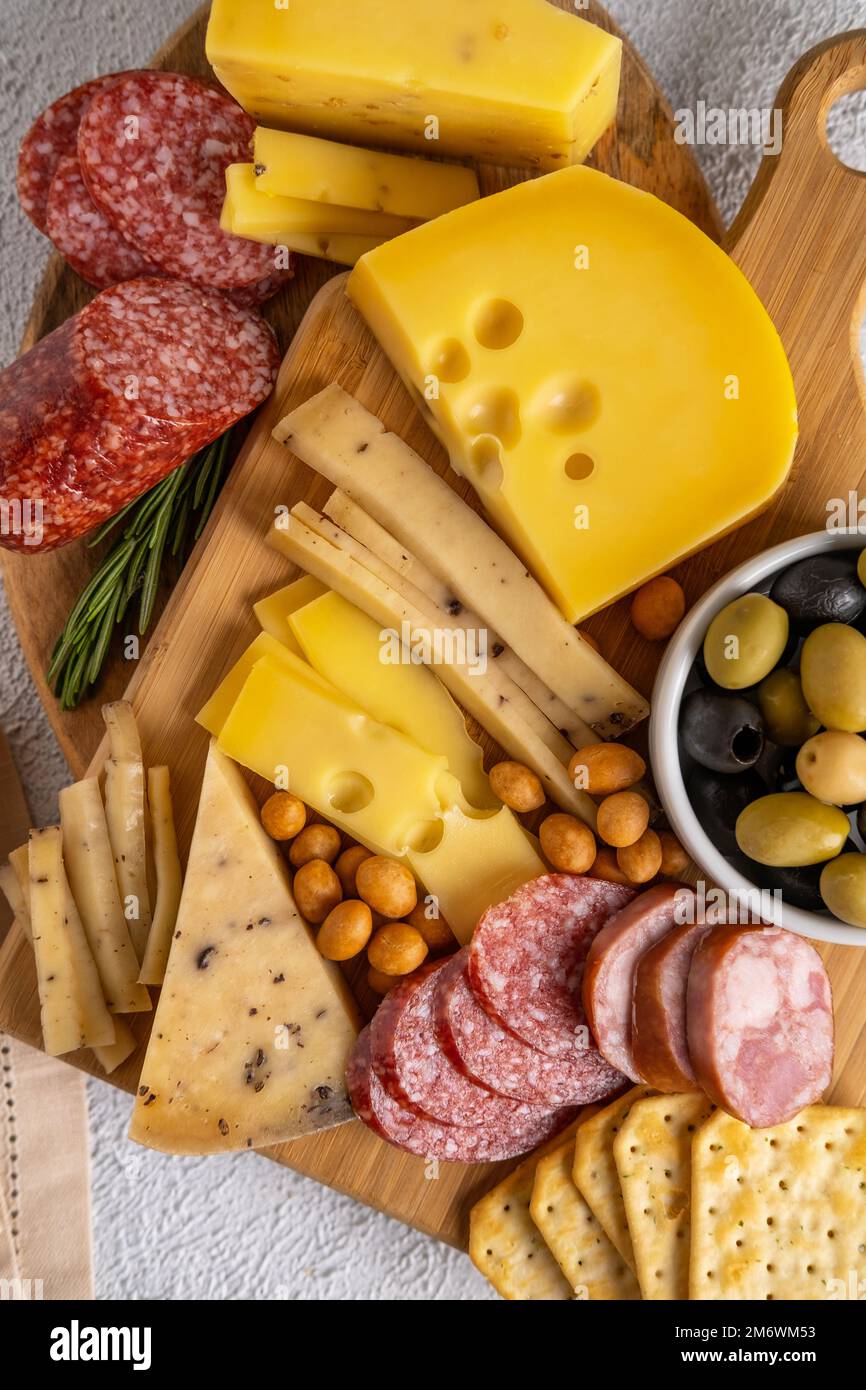 Different types of cheeses and cold cut meats. Top view on a white