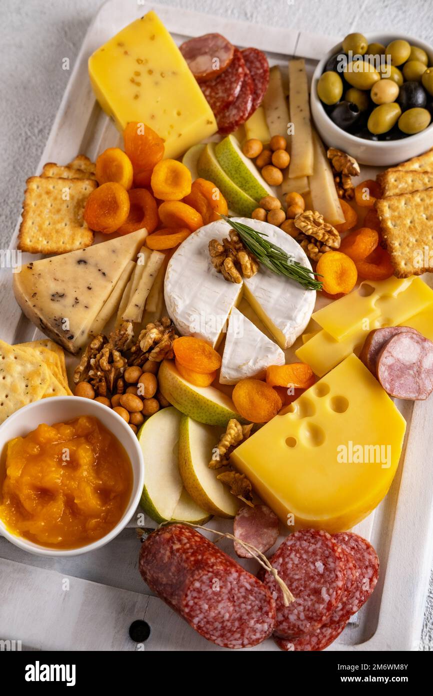 Different types of cheeses and cold cut meats. Top view on a white