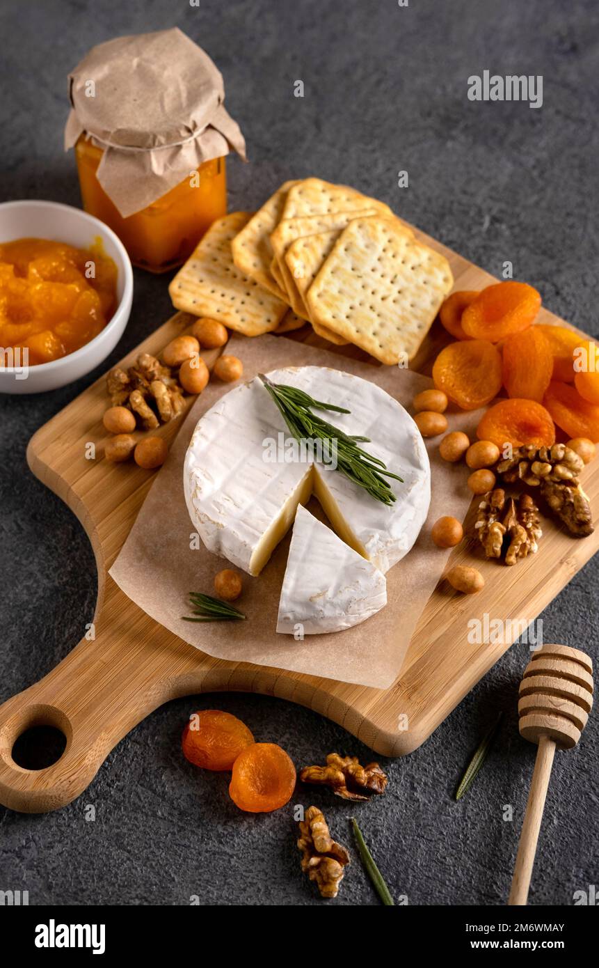 Brie cheese with nuts, pear slices and dried apricots. Camembert cheese