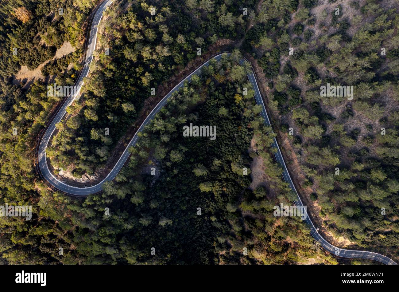 Drone aerial of mountain curved road. Adventure and challenging road trip in the forest Stock Photo