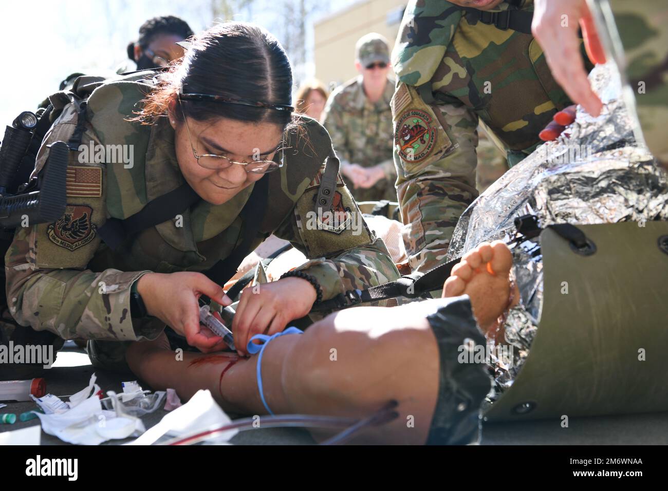 N.Y. Air National Guard 106th Rescue Wing Senior Airman Catalina Garcia-Canas, a 106th combat medic, injects medicine in the arm a “patient,” an advanced medical simulation dummy, at Joint Base Elmendorf-Richardson in Anchorage, Alaska, May 5, 2022. The combat medics of the 106th Medical Group participated in their first Military Facility Annual Training since the start of the COVID-19 pandemic, and were expected to encounter a patient, assess the injuries, mitigate the risk, stop bleeding, treat secondary wounds, and/or resuscitate the patient and maintain the airway. (Air National Guard phot Stock Photo