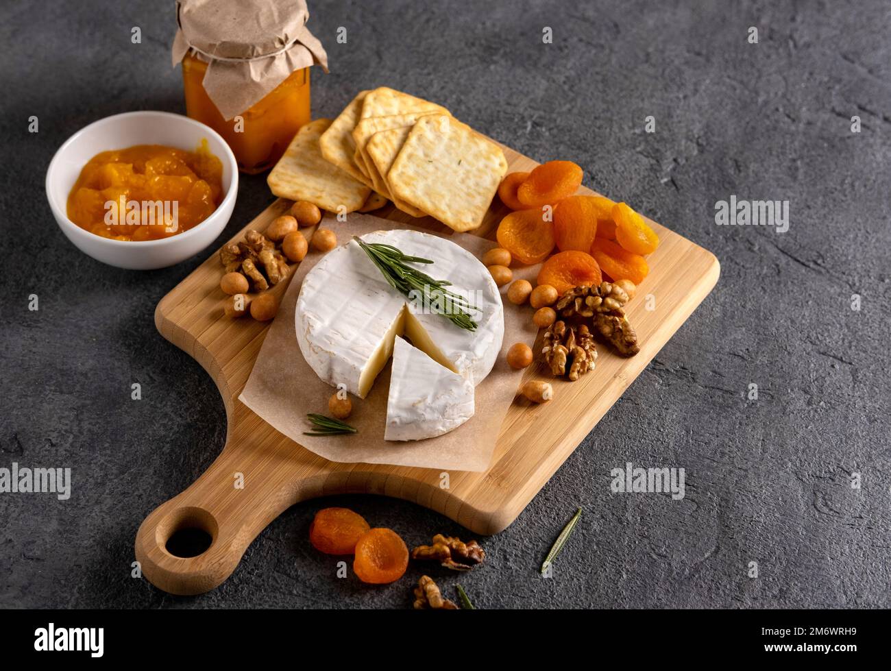 Brie cheese with nuts, pear slices and dried apricots. Camembert cheese. Brie cheese or