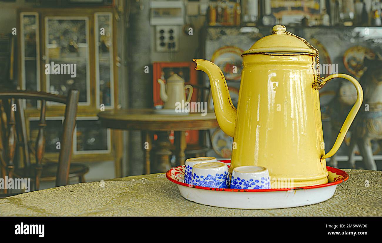 A tray of tea set on a round table consists of a teapot and 3 ceramic