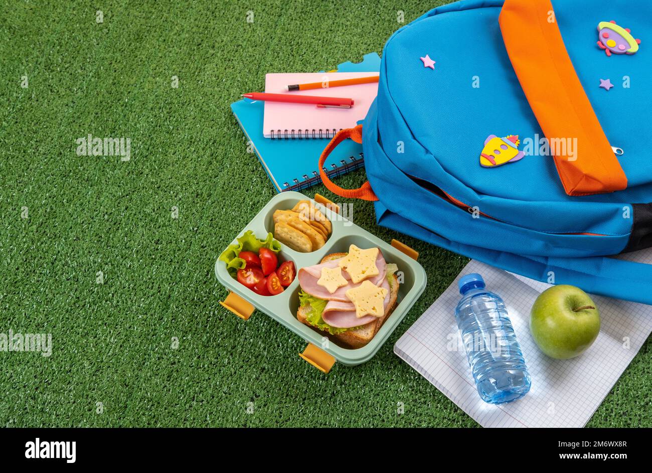 Healthy school lunch box with sandwich and salad at school yard. School