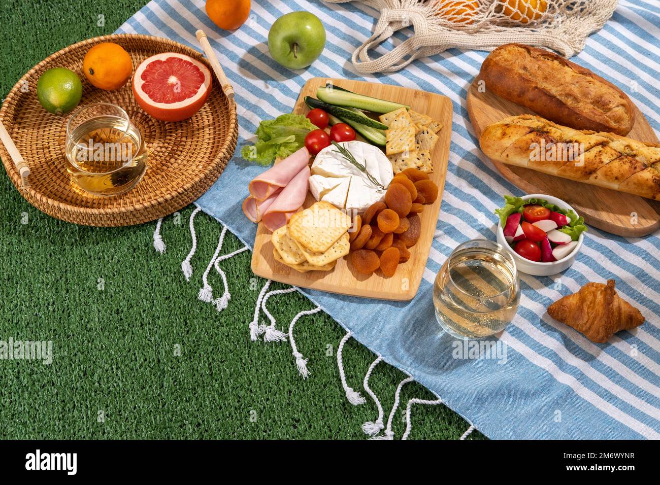 https://c8.alamy.com/comp/2M6WYNR/picnic-blanket-with-charcuterie-boards-healthy-food-and-wine-in-park-on-the-grass-on-sunny-day-2M6WYNR.jpg
