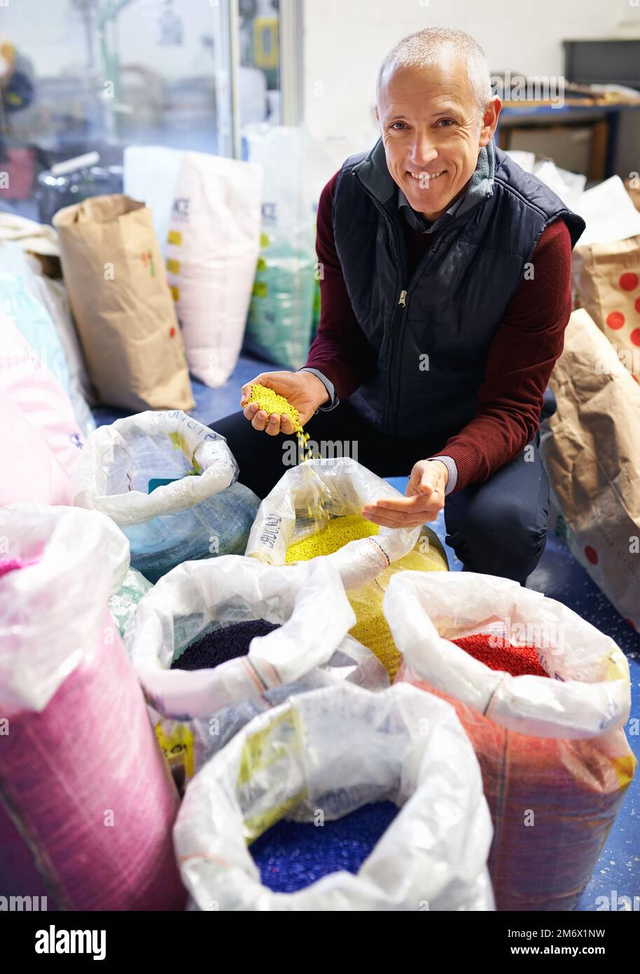 Put some color into it. A plastics factory owner inspecting his merchandise. Stock Photo