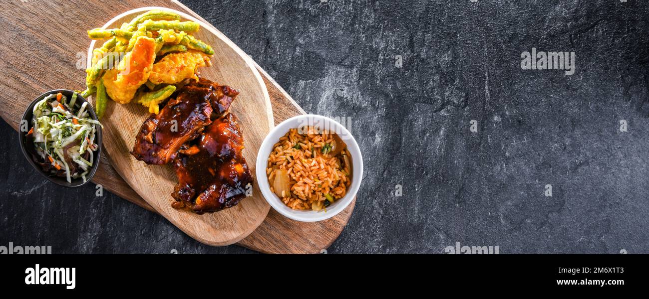 Chicken thighs in tamarind sauce with tom yum wok fried rice and veggies  tempura Stock Photo - Alamy