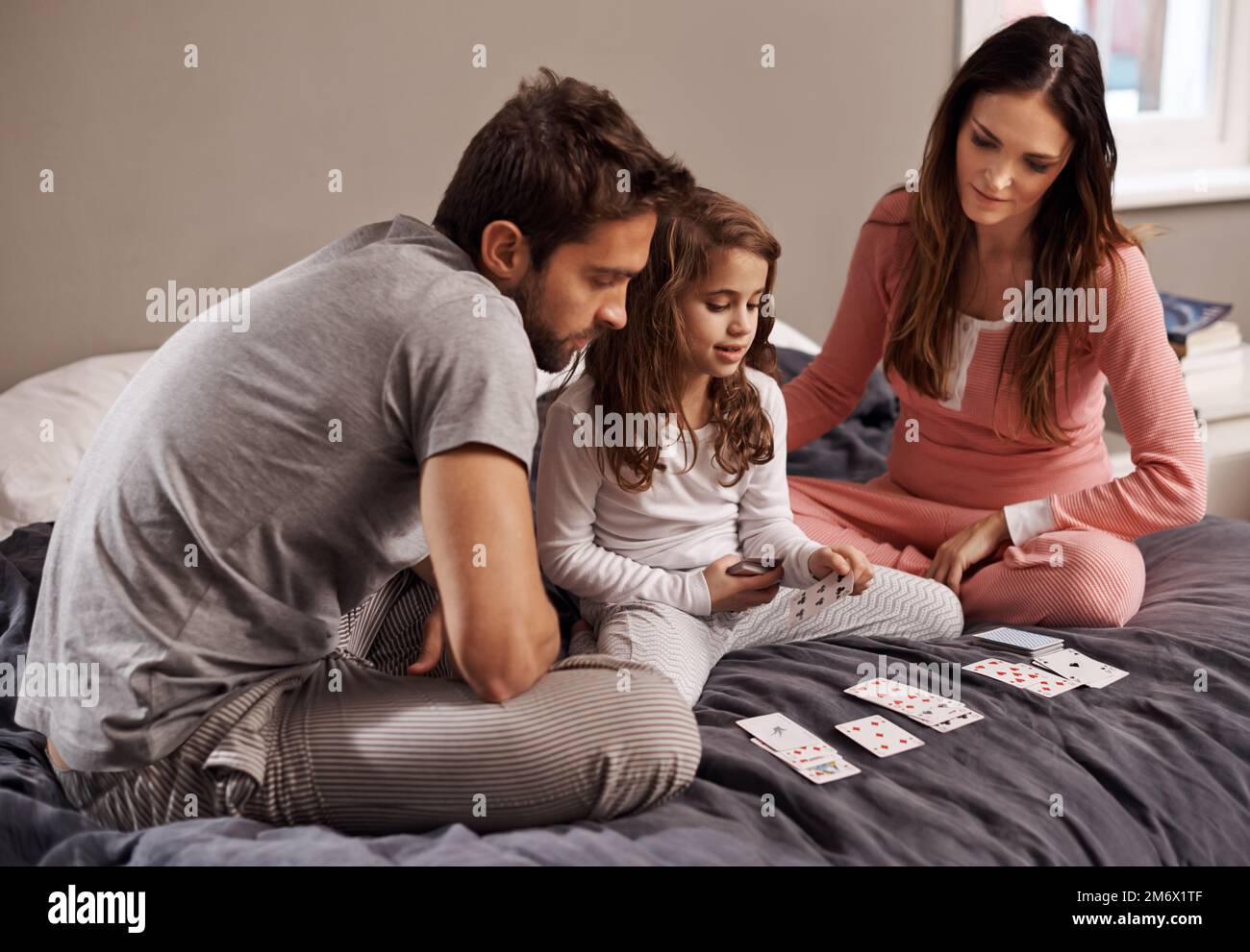 How to spend a weekend...a young family playing cards together at home ...