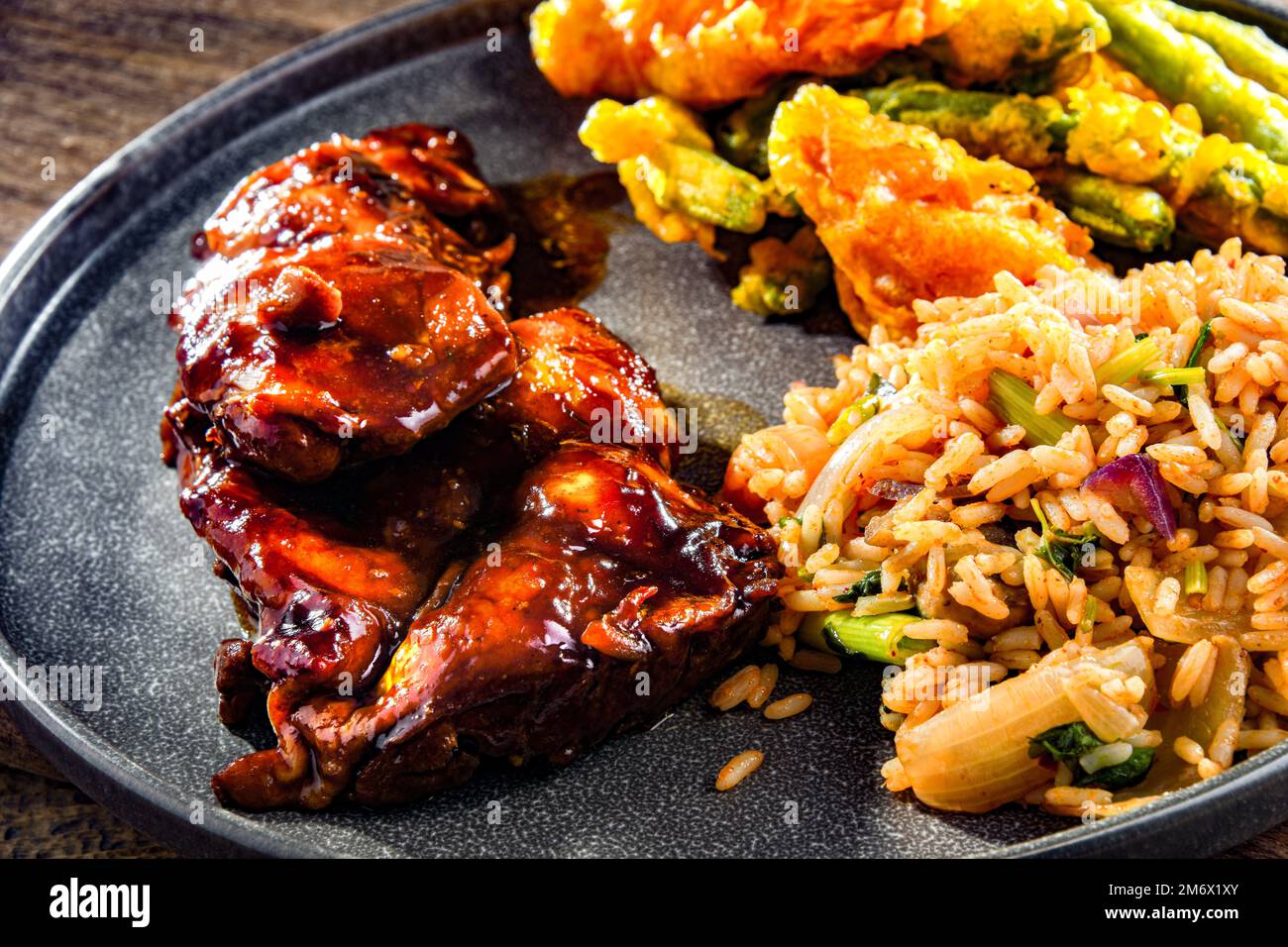 Chicken thighs in tamarind sauce with tom yum wok fried rice and veggies  tempura Stock Photo - Alamy