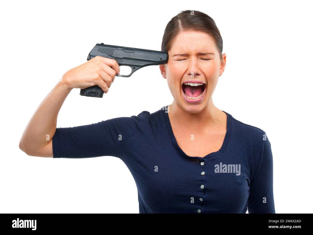 Ive had enough. Studio shot of a young woman pointing a gun at her head isolated on white. Stock Photo