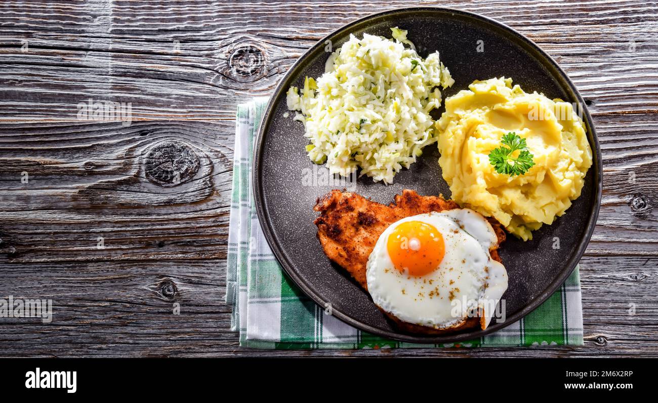 Breaded chicken cutlet served with fried chicken egg Stock Photo Alamy