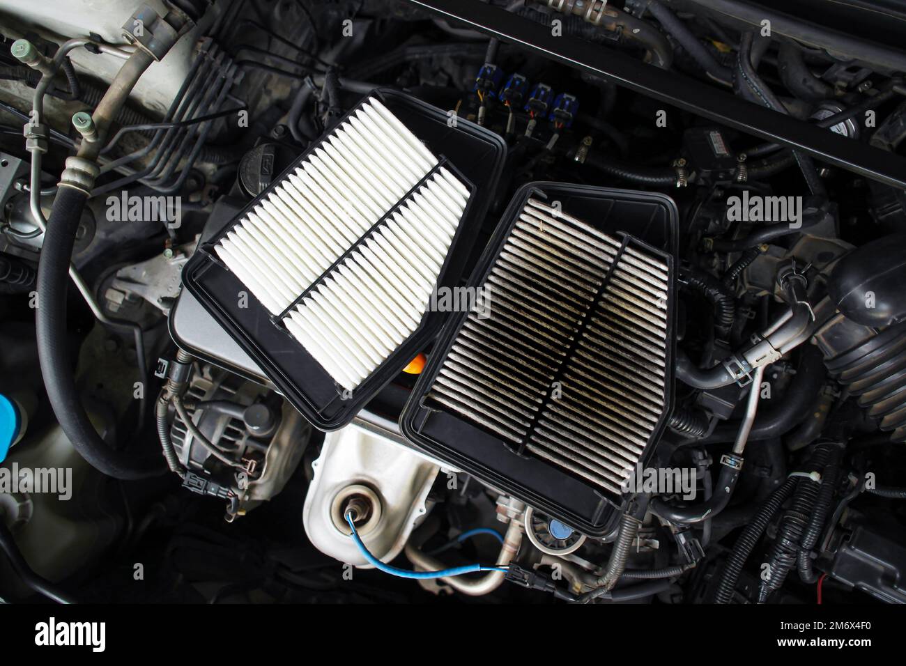 Comparison of new and old car air filters that are clogged up on the