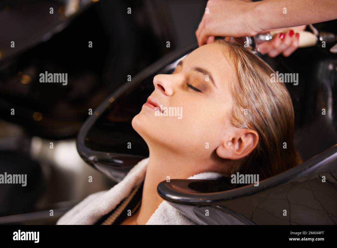 Feels so good...a young woman having her hair washed at a hair salon. Stock Photo