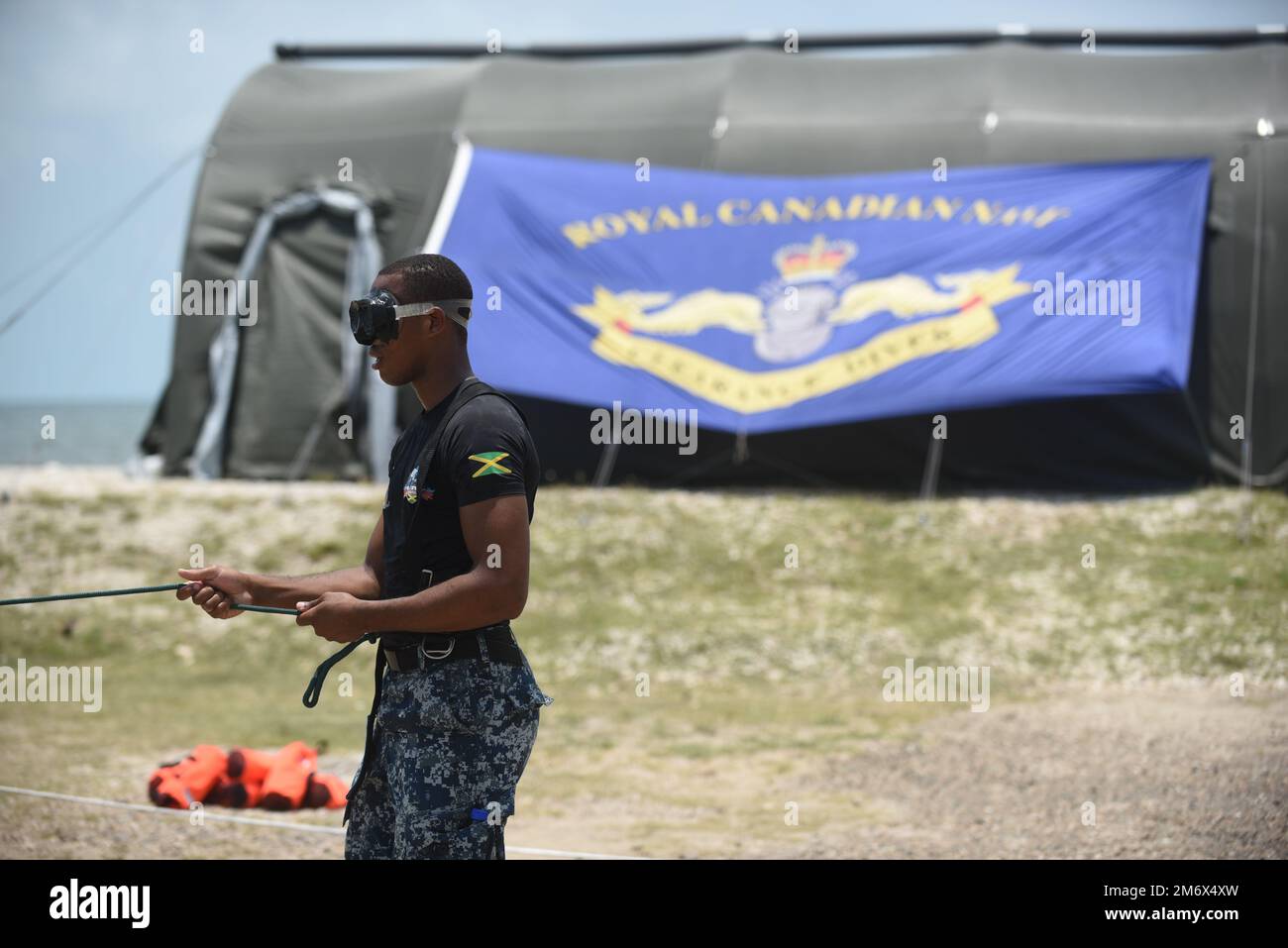 A member from the Caribbean Military Maritime Training Centre in Jamaica participates in line signal training with the Royal Canadian Navy during Tradewinds 2022 in Belize City, Belize, on May 8, 2022. Line signals are used to establish communications between the dive supervisor and diver when no other means are available. Stock Photo