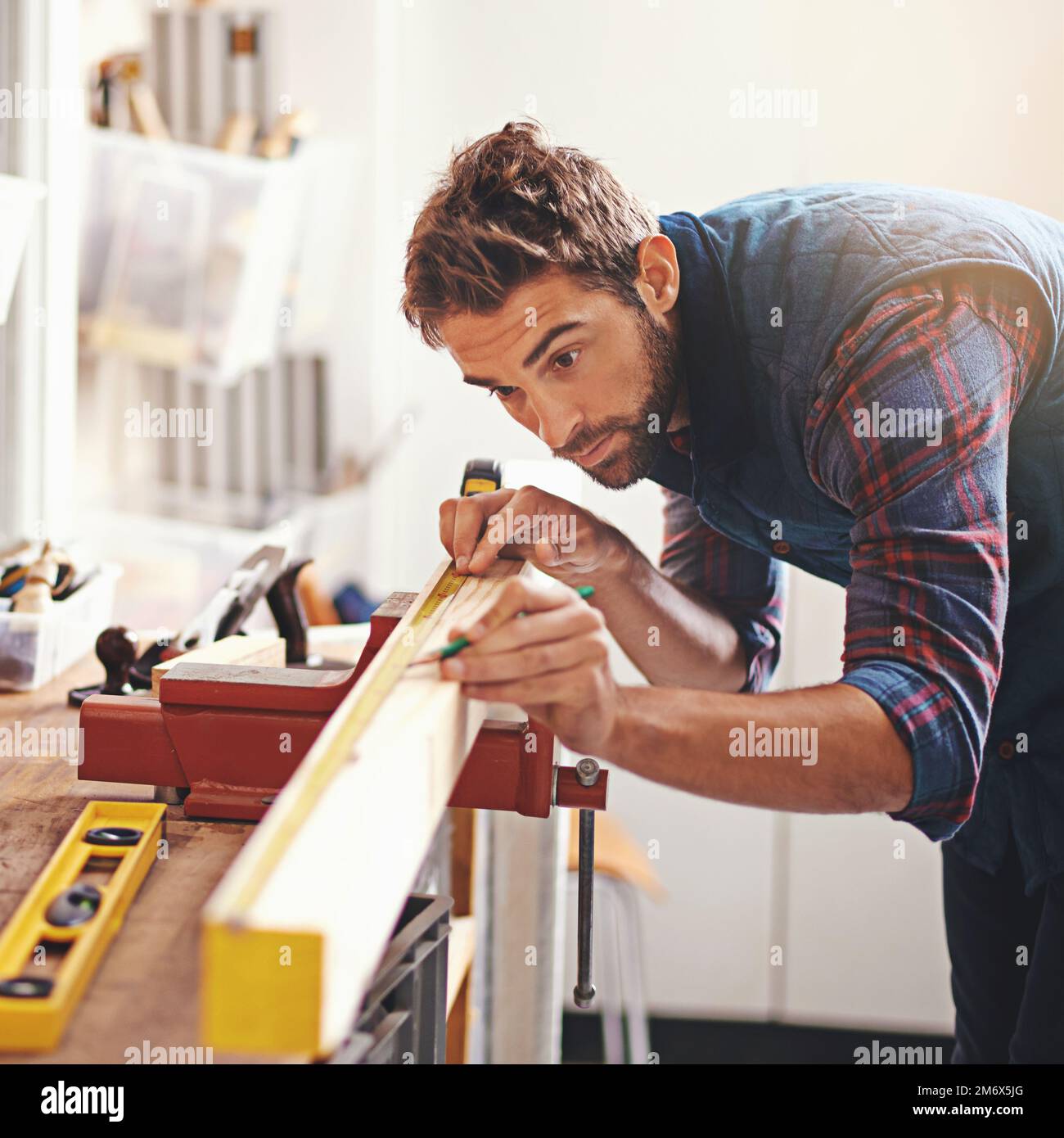 Perfection is measured in millimeters. a carpenter making measurements