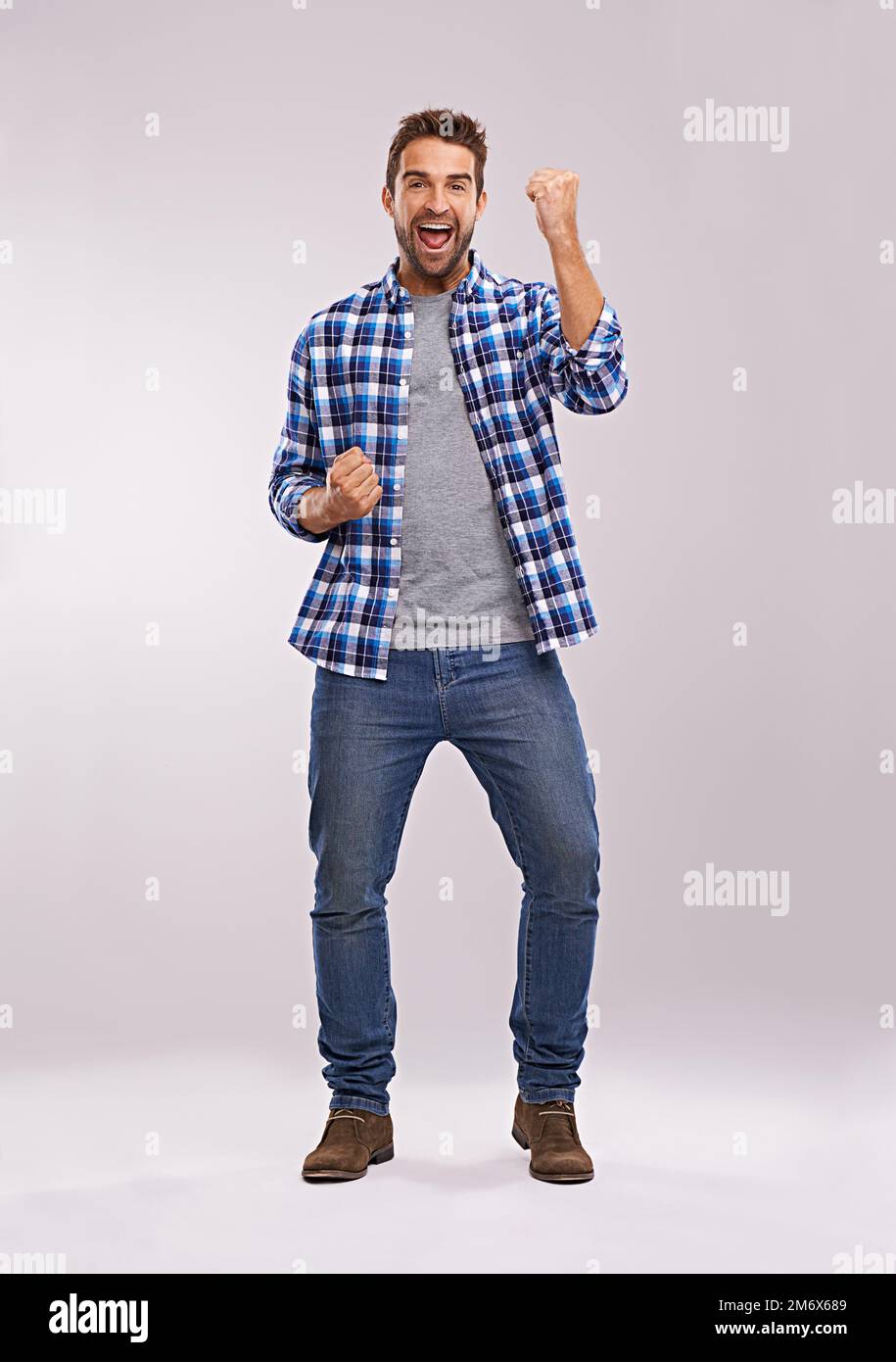 Yes. Studio shot of an enthusiastic and handsome man against a gray background. Stock Photo