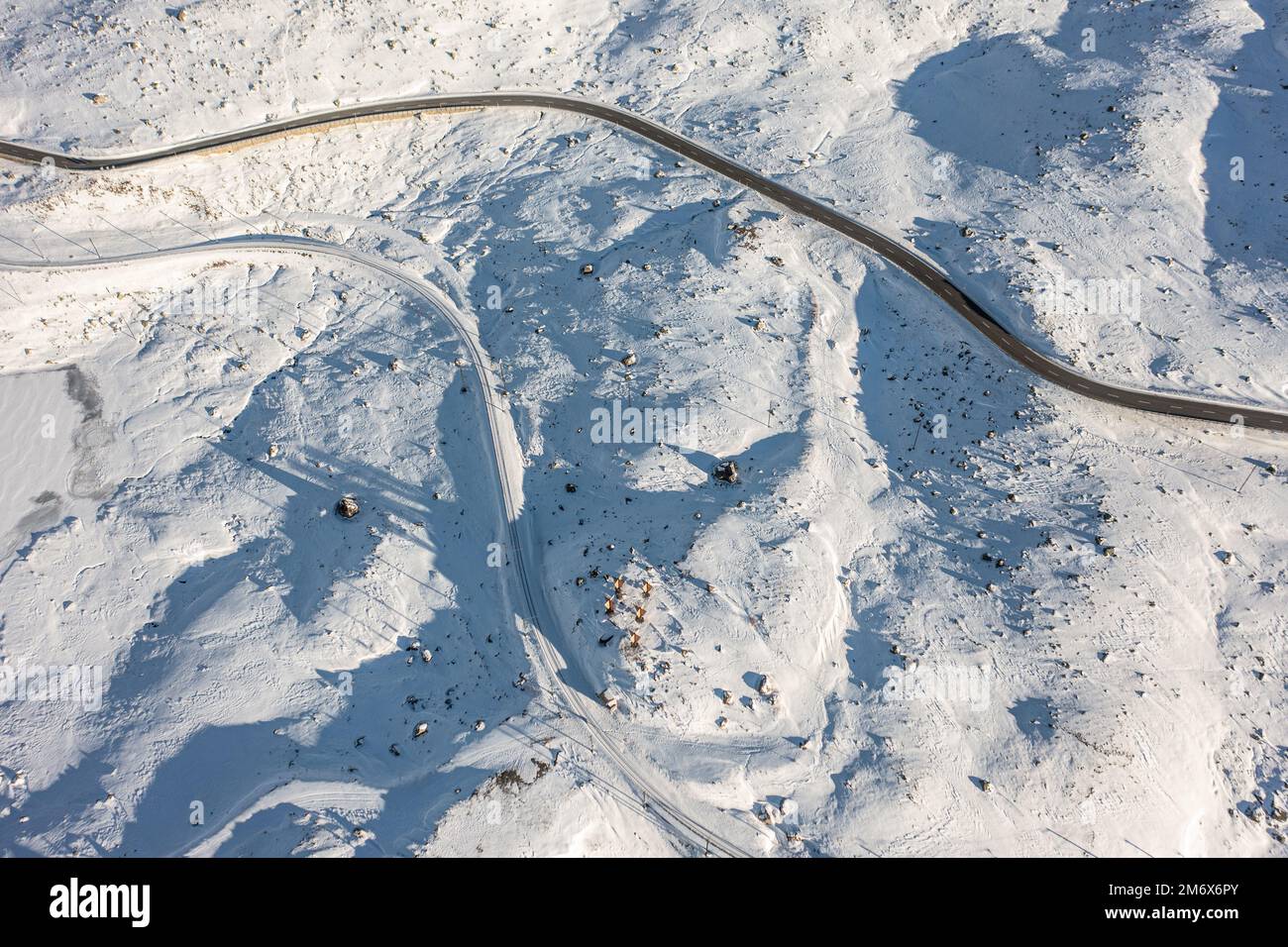 An aerial view of a road in the snowy white field on the hillside Stock ...