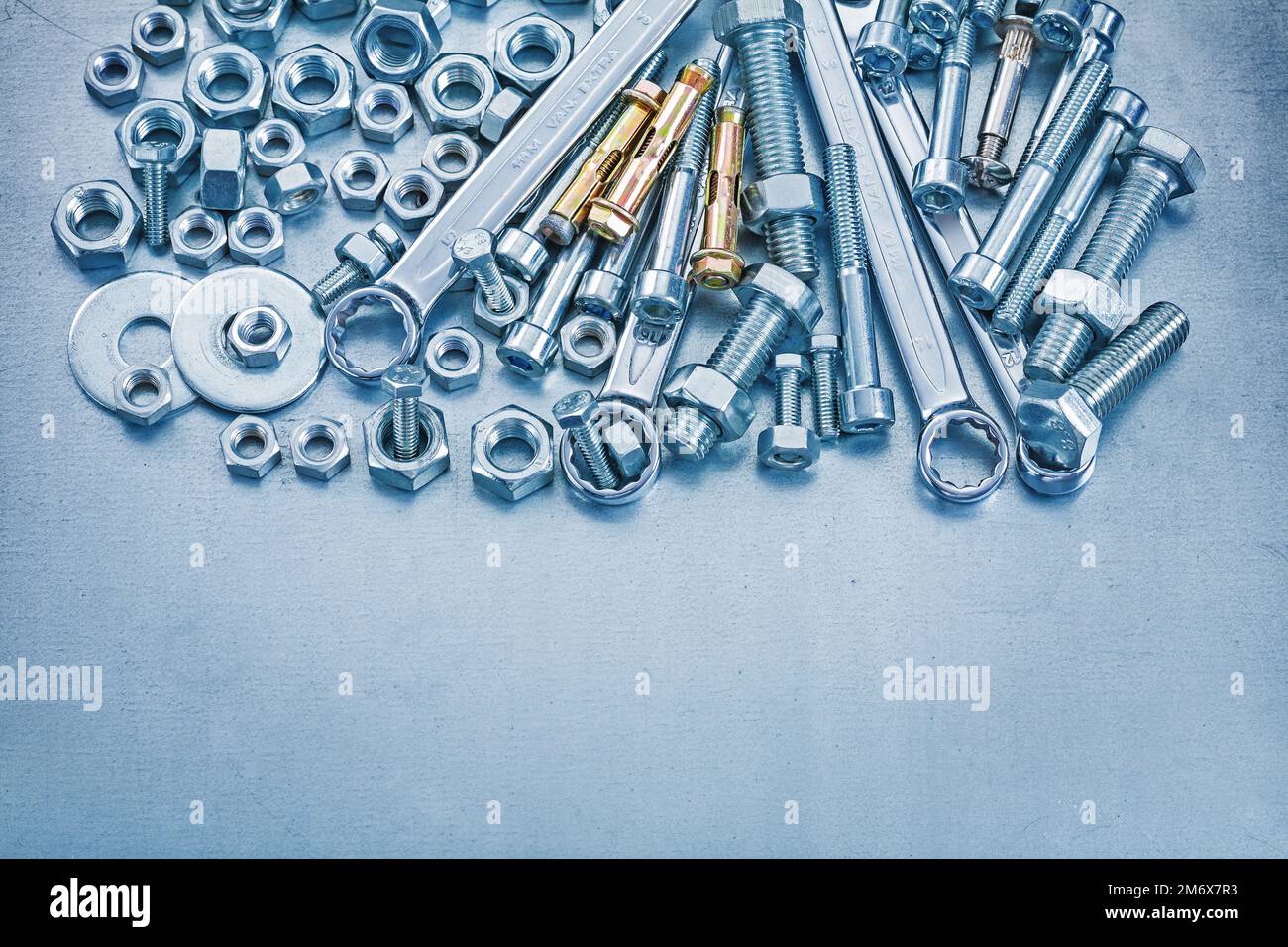 Anchor bolt washers screwbolts construction nuts and flat spanner on metallic background
