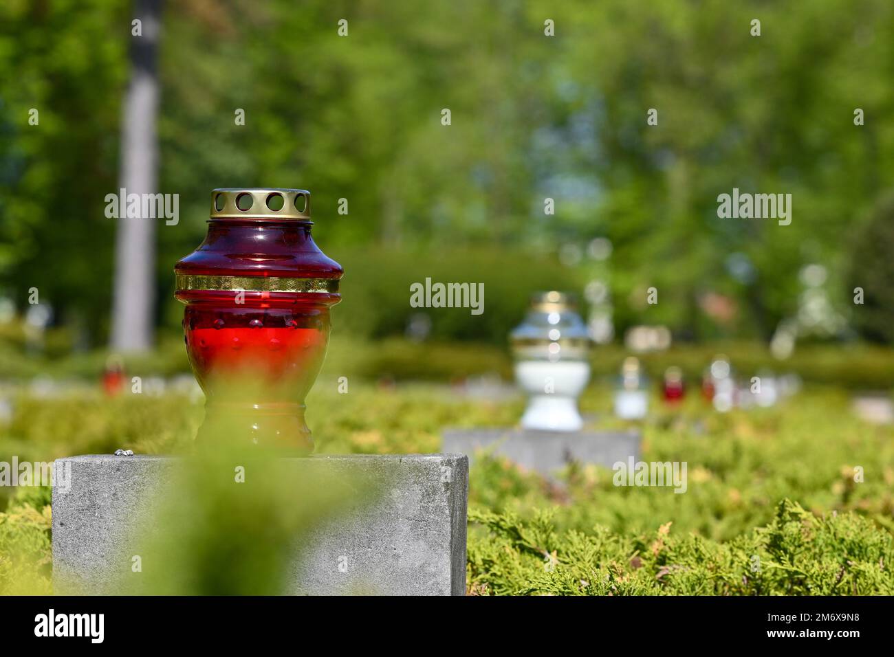 Candles sit on tombstones after a Victory Day ceremony at Drawsko Pomorskie, Poland, May 8, 2022. Victory Day, or V-E Day in the United States, recognizes the end of World War II in the European theater, and remembers the sacrifices of service members and civilians lost during the conflict. Stock Photo