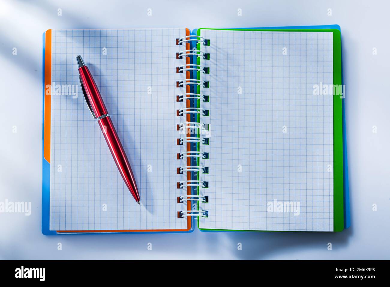 Checked notepad pen on white background. Stock Photo