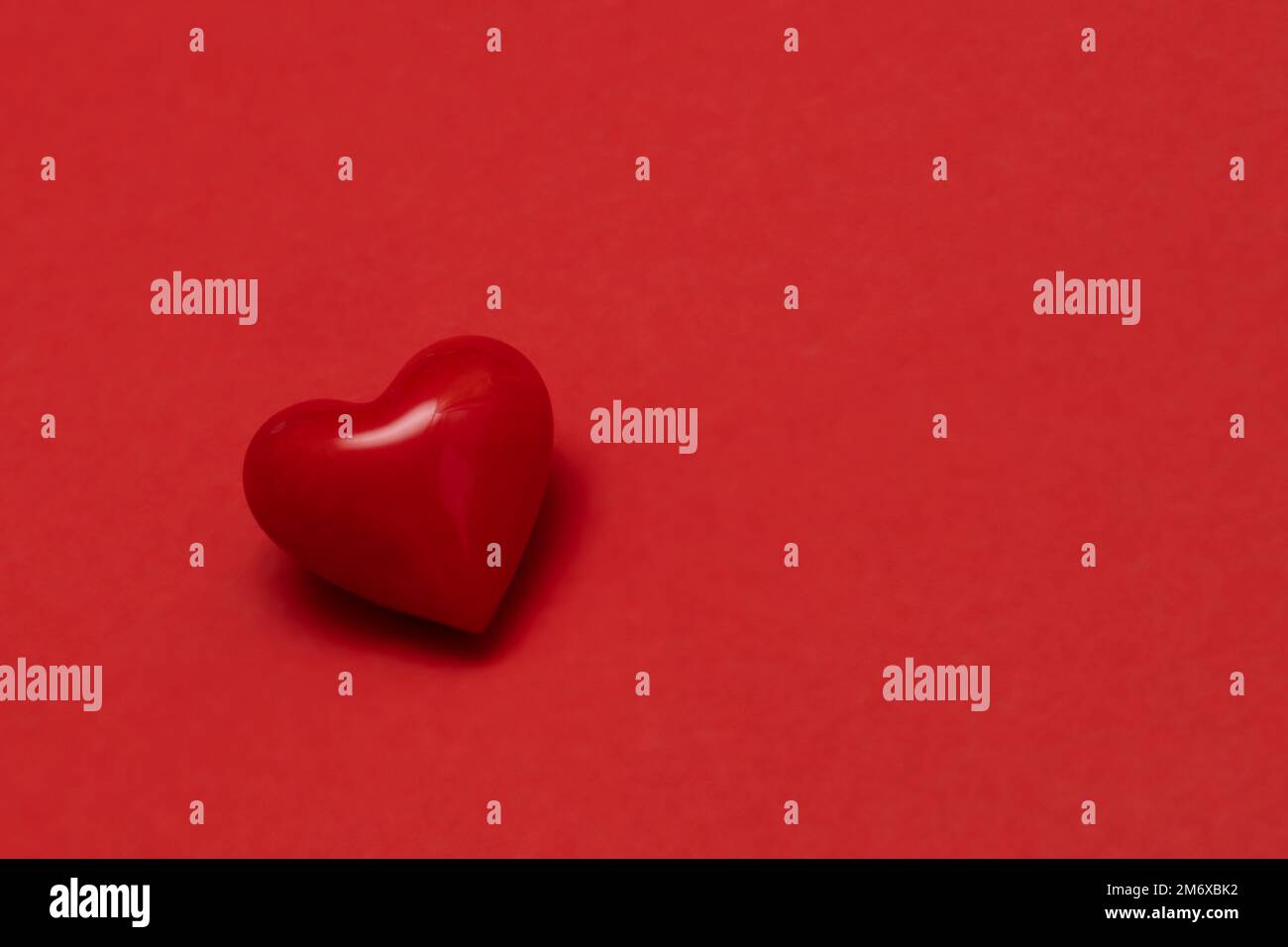 Valentines day red heart on same color background. Monochromatic vivid color. Valentine's day concept. Close up, copy space. Stock Photo