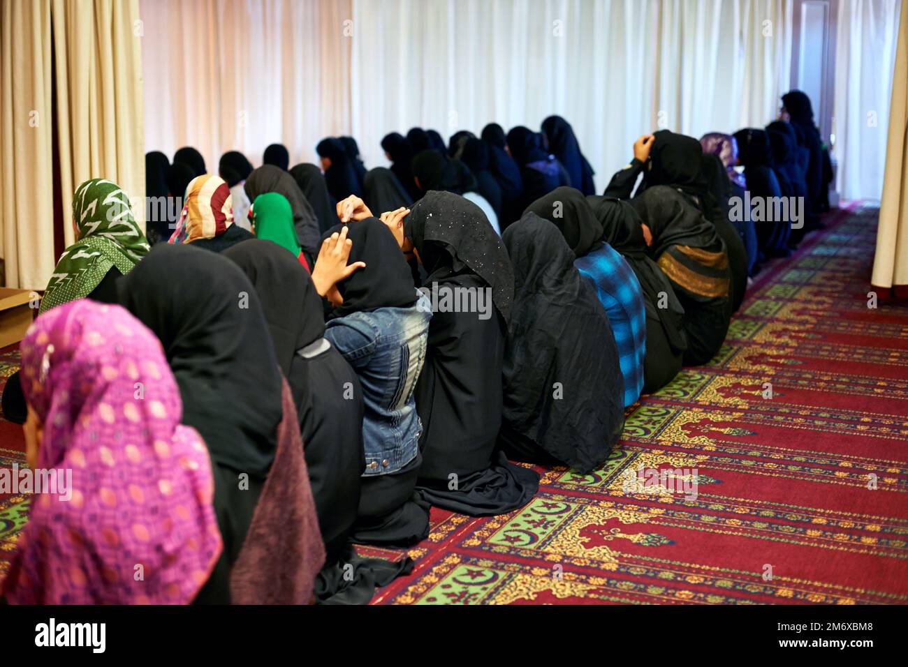 Coming together in worship. women worshipping in a mosque. Stock Photo