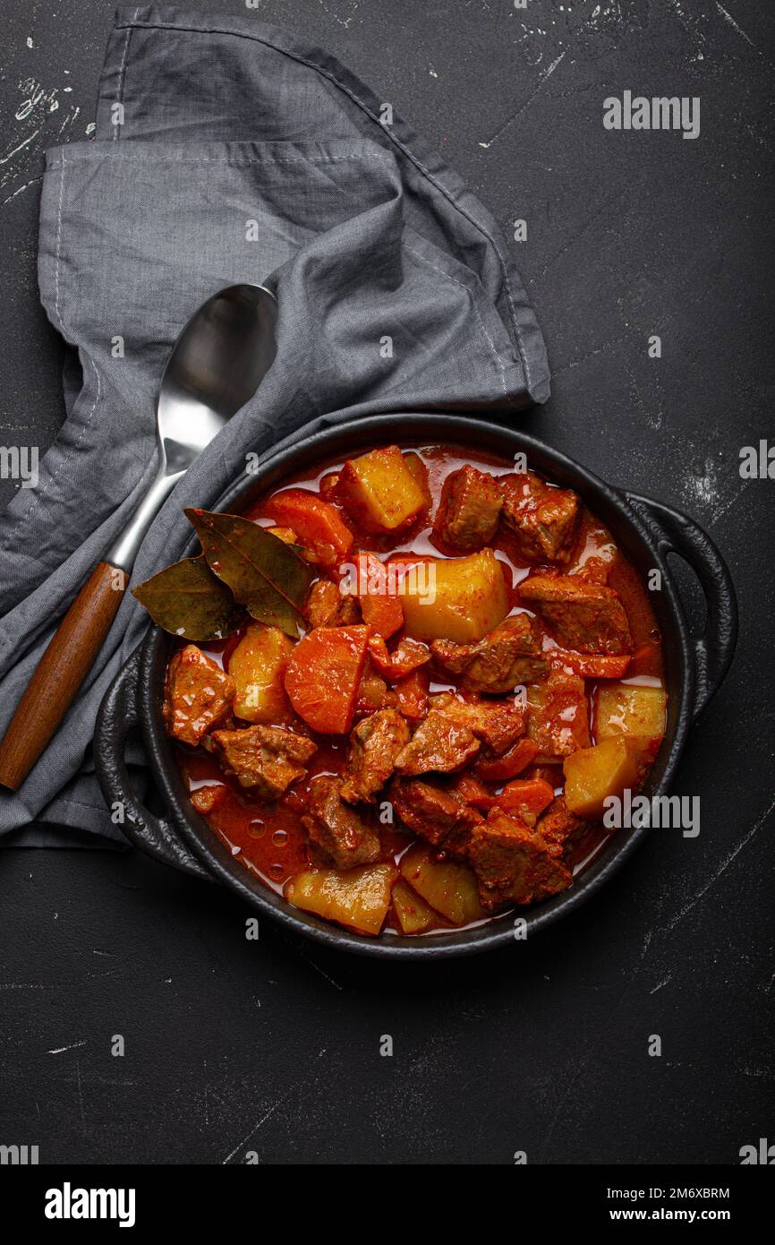 Beef meat stew with potatoes, carrot and delicious gravy in black