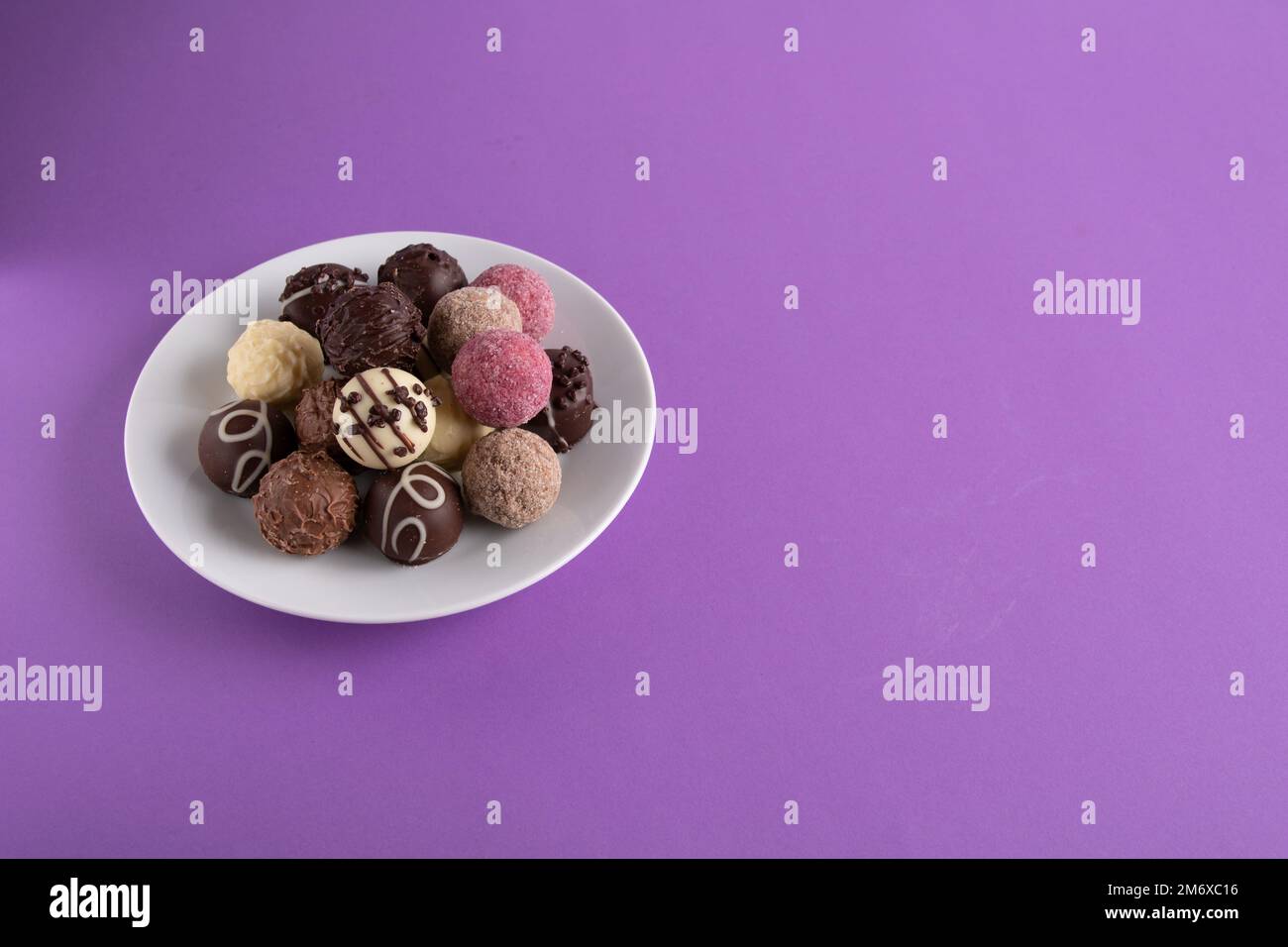 photo assorted chocolates lying in a round white plate Stock Photo - Alamy
