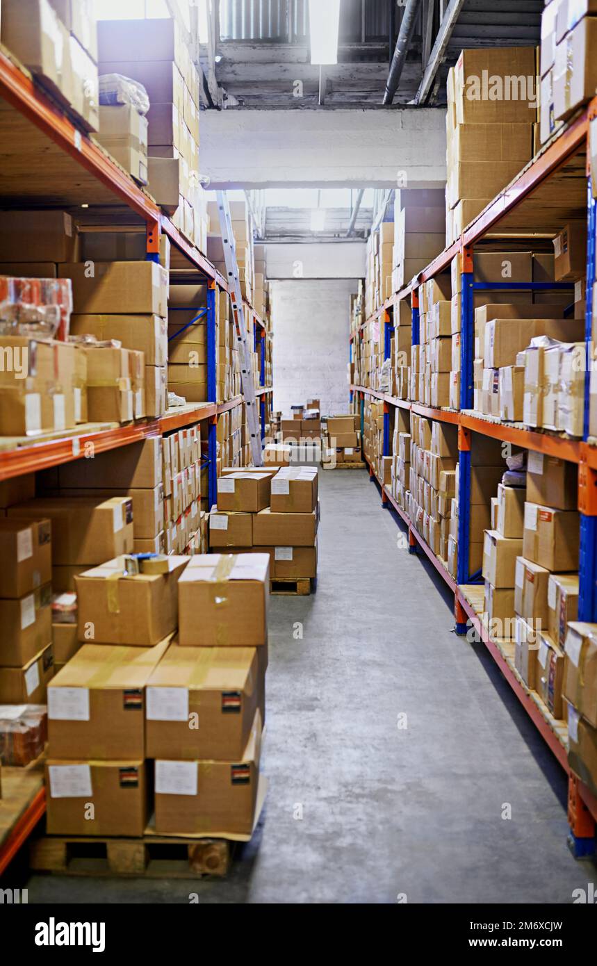 Stacked and ready to be delivered. Large warehouse storage shelves with boxes packed on them. Stock Photo