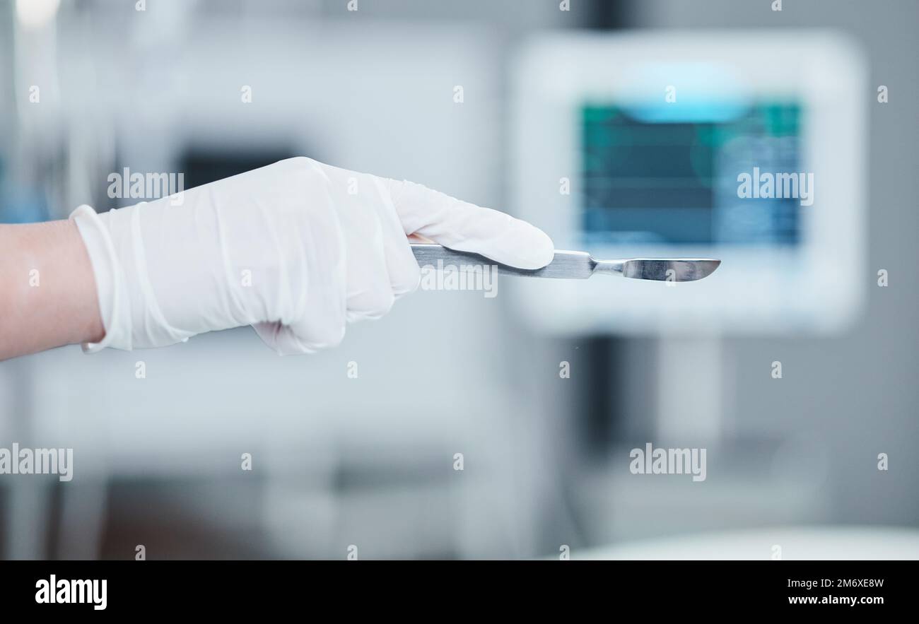 Scalpel, surgery and doctor hand for medical tools, innovation and hospital healthcare insurance, trust and theatre background. Metal equipment Stock Photo