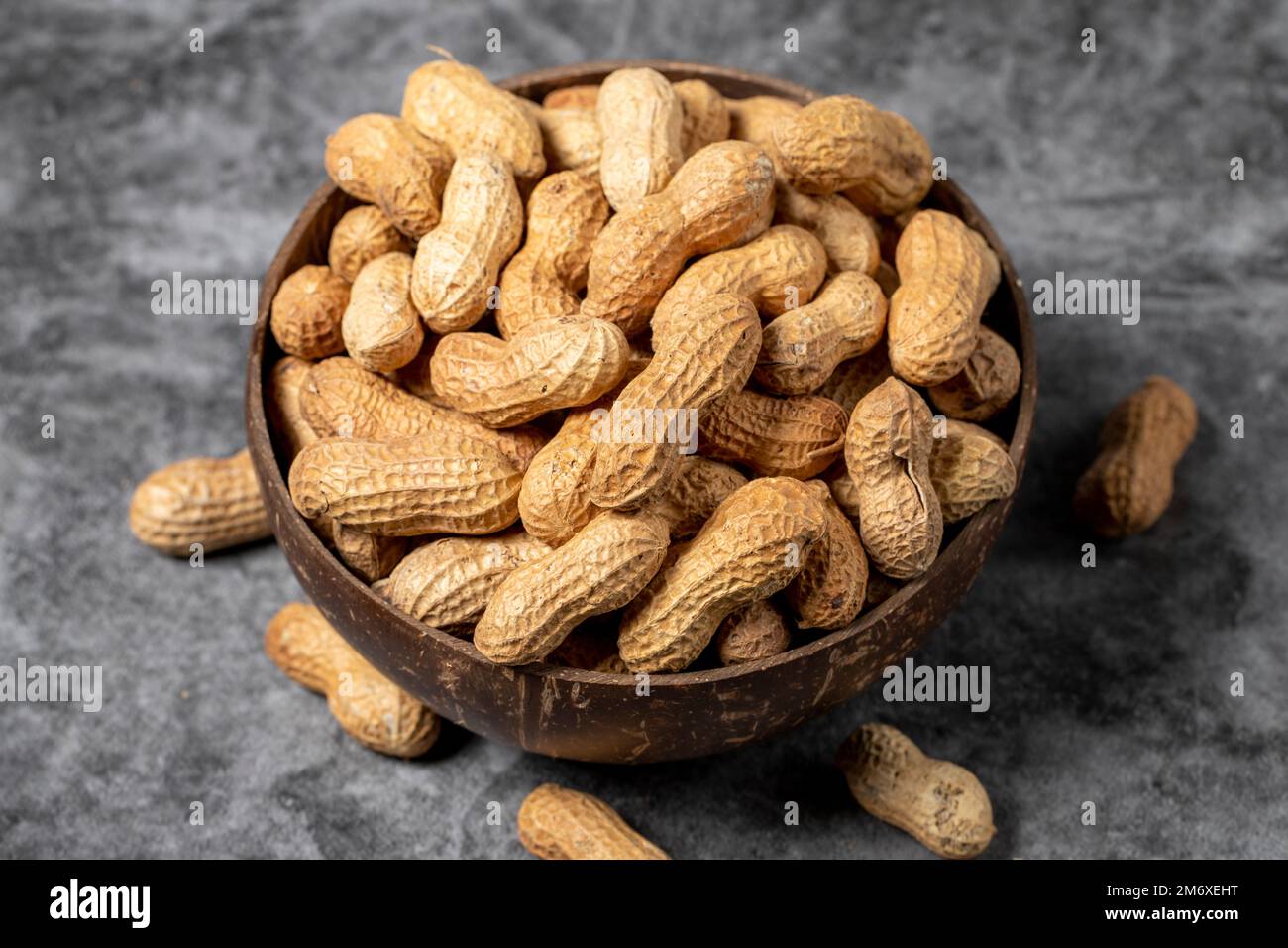 Peanuts in shell on dark background. Peanuts in a coconut bowl. close