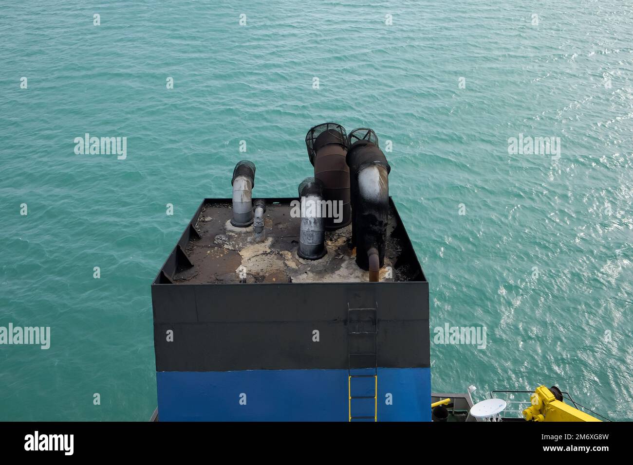 View from above the chimney of an anchored cargo ship. Stock Photo