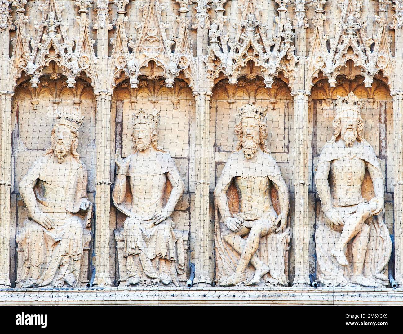 A row of four statues, english kings sitting on thrones, on the west