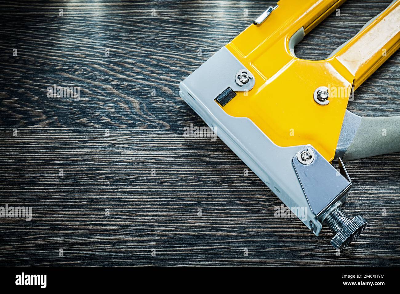 Construction stapler gun on wooden board. Stock Photo
