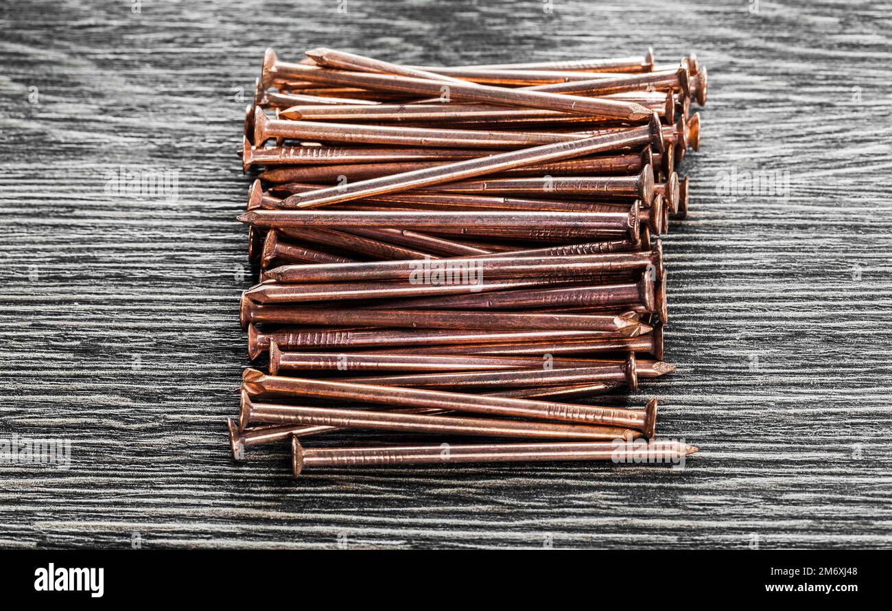 Copper nails on wooden board. Stock Photo