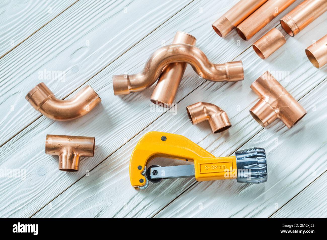 copper pipes and fittings pipecutter on white boards Stock Photo