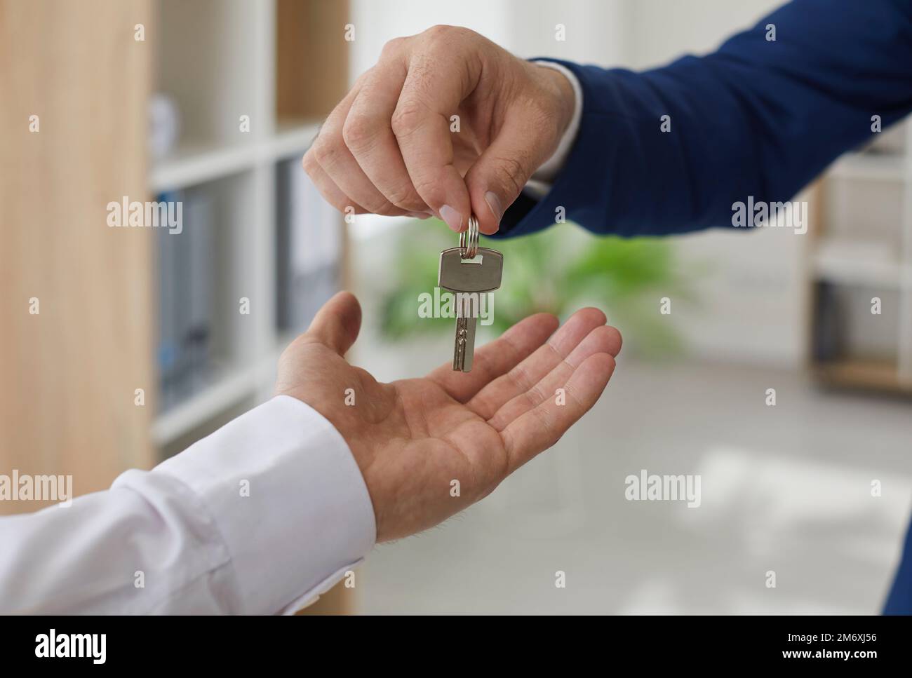 Real estate agent handing over the keys to the owner of a new house or ...