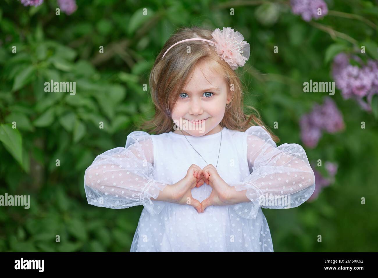 Portrait of a young and beautiful caucasian girl shows the heart sign Stock Photo