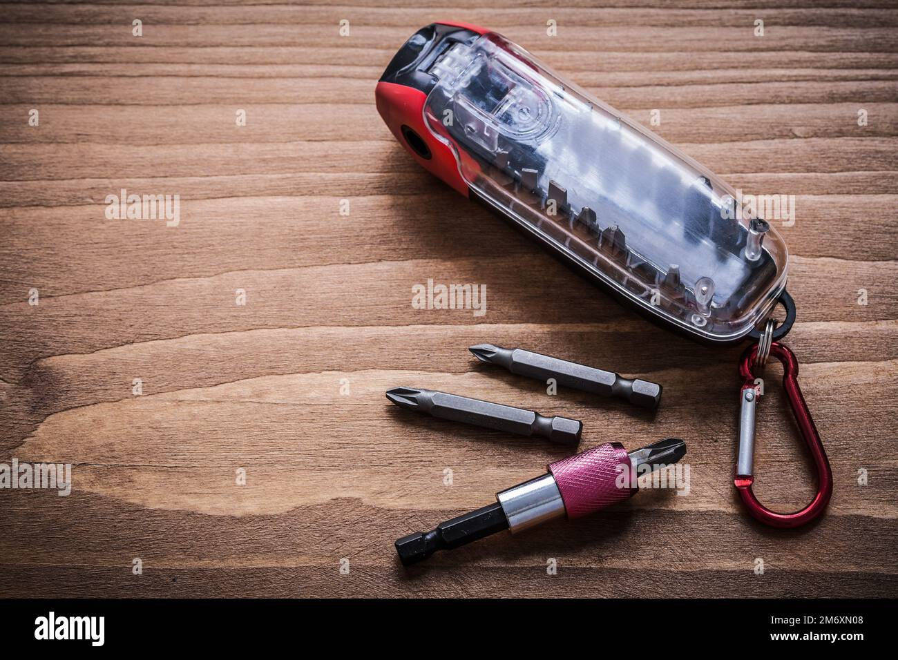 Interchangeable screwdriver heads in container on wood board horizontal version. Stock Photo