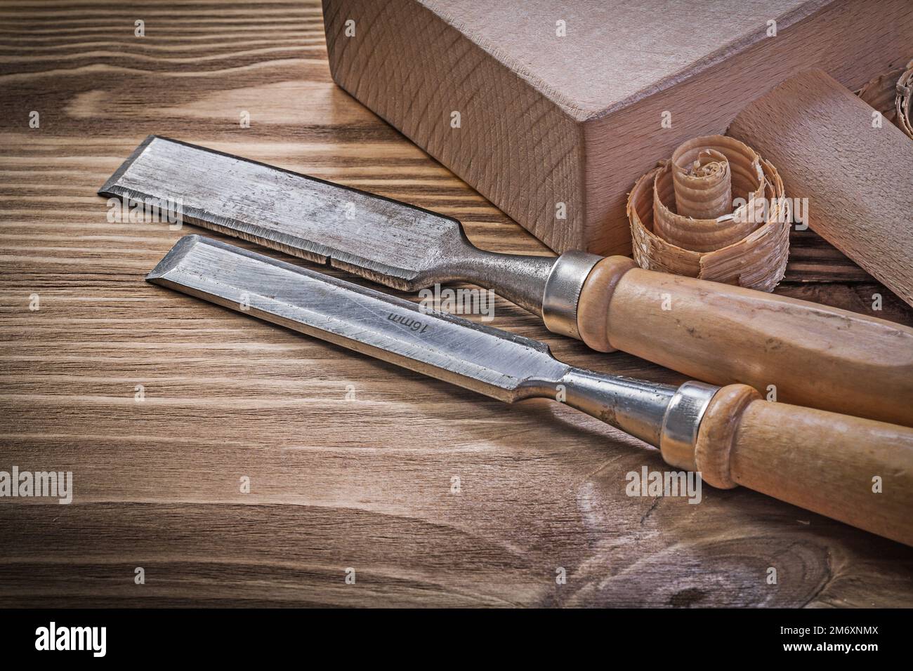 Lump hammer chisels curled scobs on vintage wood board construction concept. Stock Photo