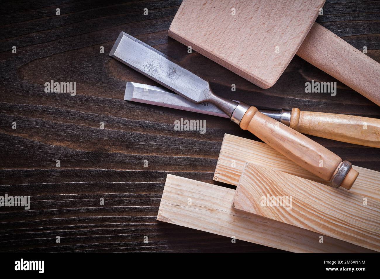 Mallet firmer chisels and wooden planks on brown vintage wood background construction concept. Stock Photo