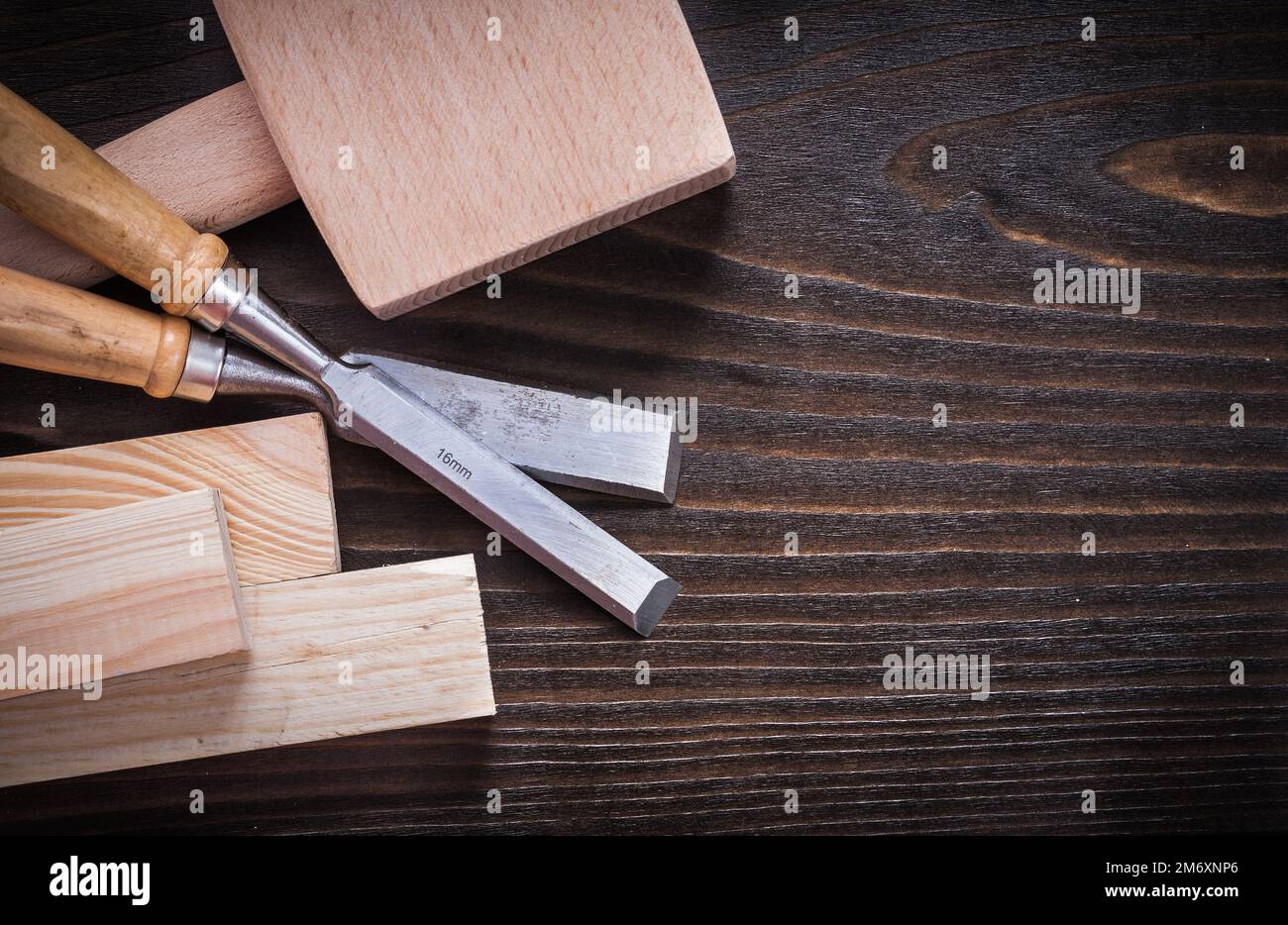 Lump hammer firmer chisels and wooden planks on brown hardwood construction concept. Stock Photo