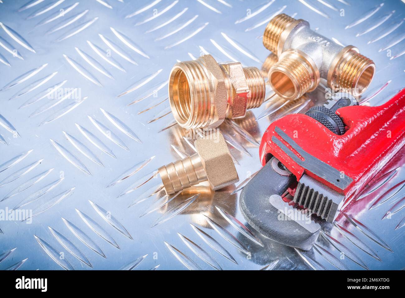 Composition of brass hardware on grooved metal plate plumbing concept