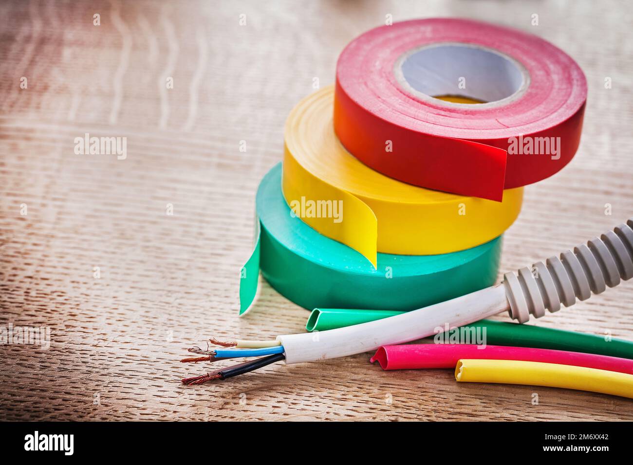 horizontal view electric cable in corrugated pipe rolls of isulating tape heat shrinkable tubes on wooden board Stock Photo