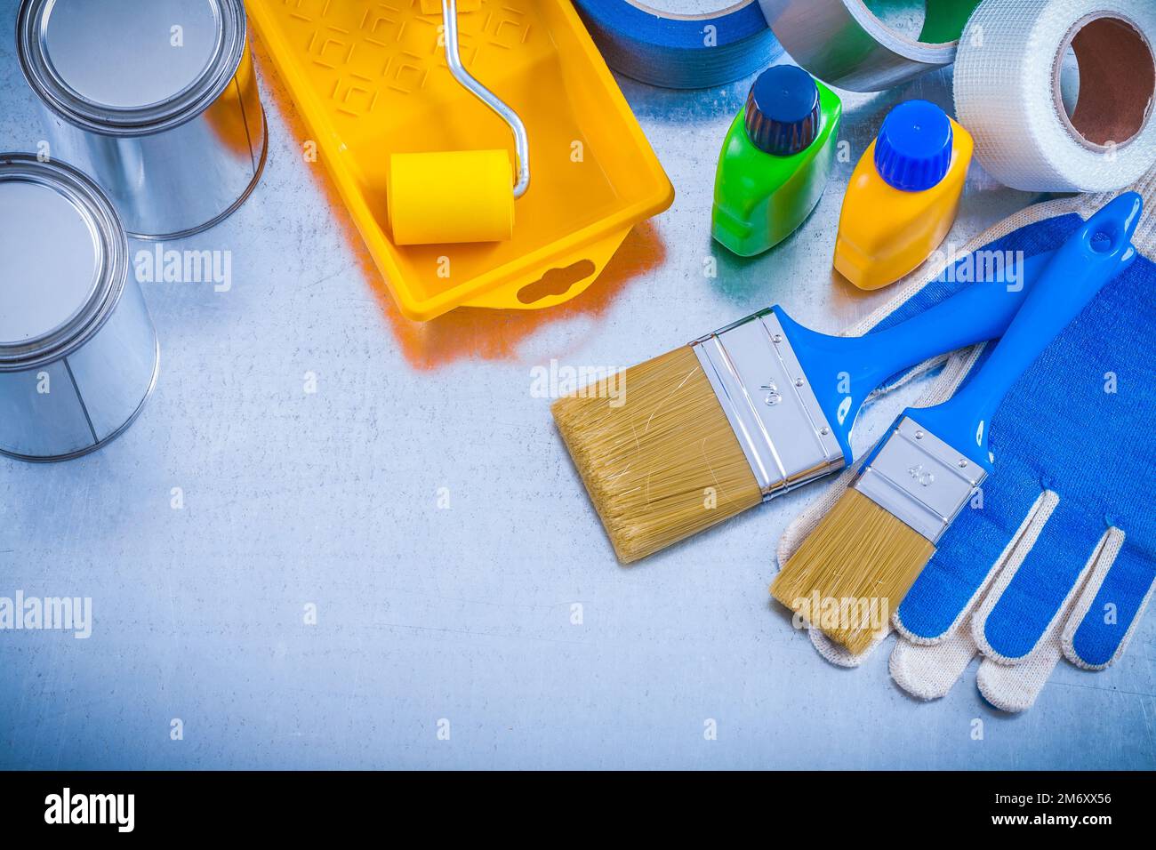 Household tapes protective gloves and paint tools on metallic