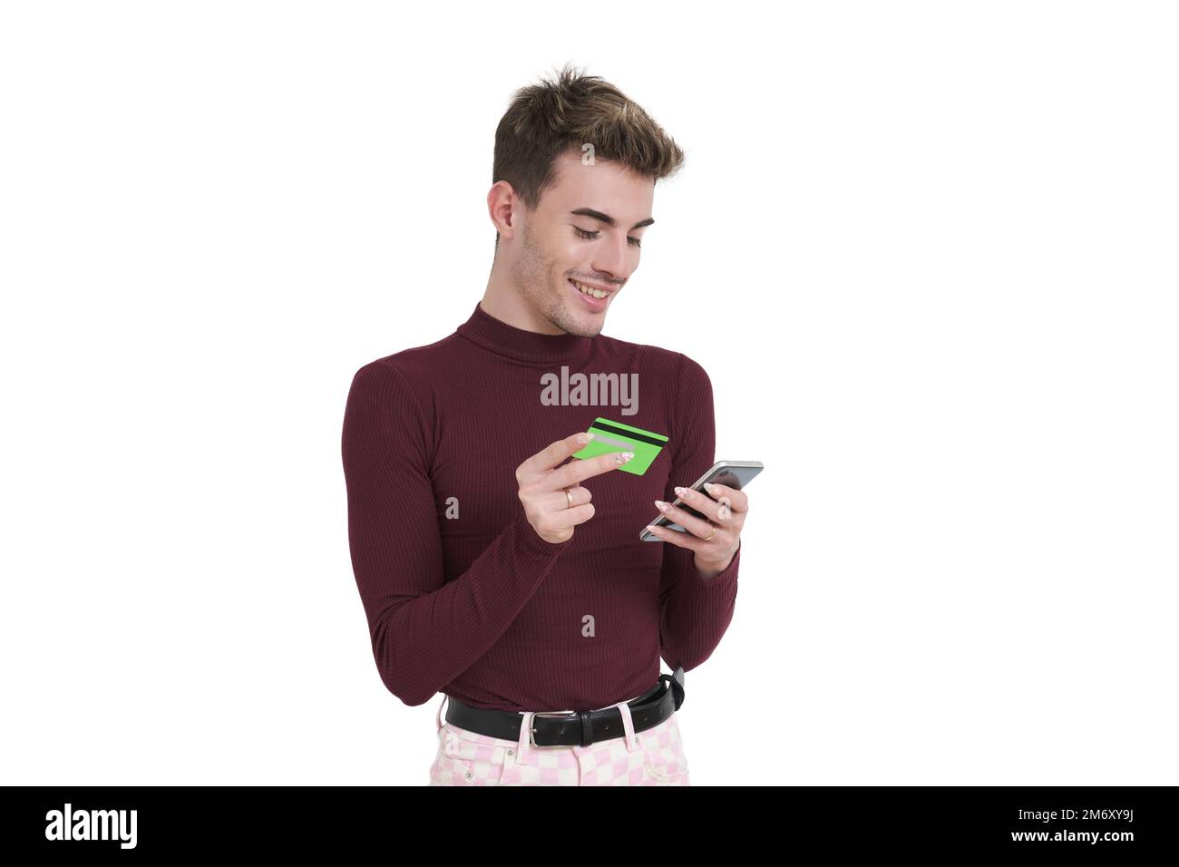 Young caucasian man smile buying online using the phone, isolated. Stock Photo