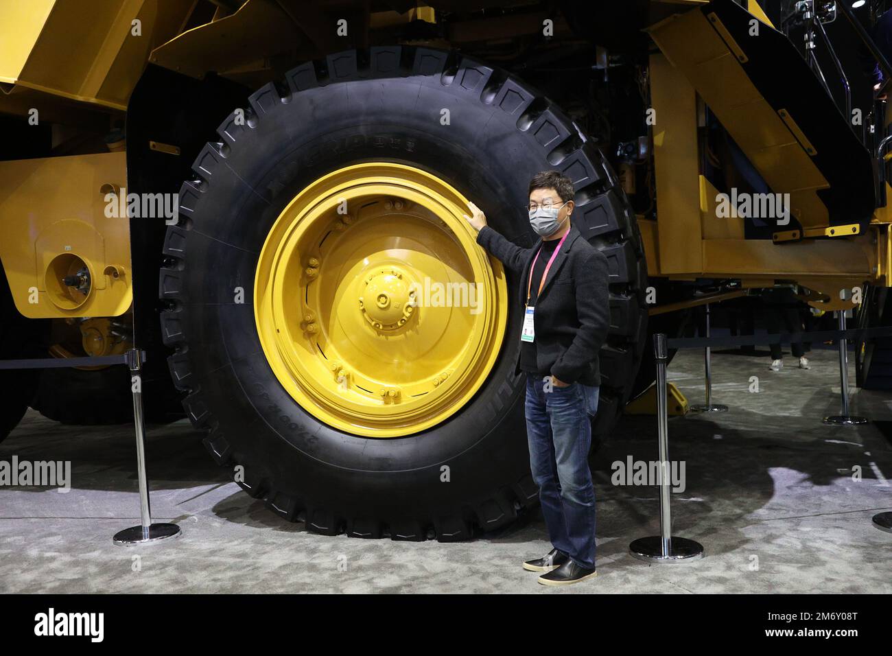 Las Vegas, United States. 05th Jan, 2023. An attendee poses for a photo next to the tire of a Cat777 haul truck, during the 2023 International CES, at the Las Vegas Convention Center in Las Vegas, Nevada on Thursday, January 5, 2023. The Caterpillar 777 is a 100-ton haul truck, typically used in open pit mining, manufactured by Caterpillar Inc. Photo by James Atoa/UPI Credit: UPI/Alamy Live News Stock Photo