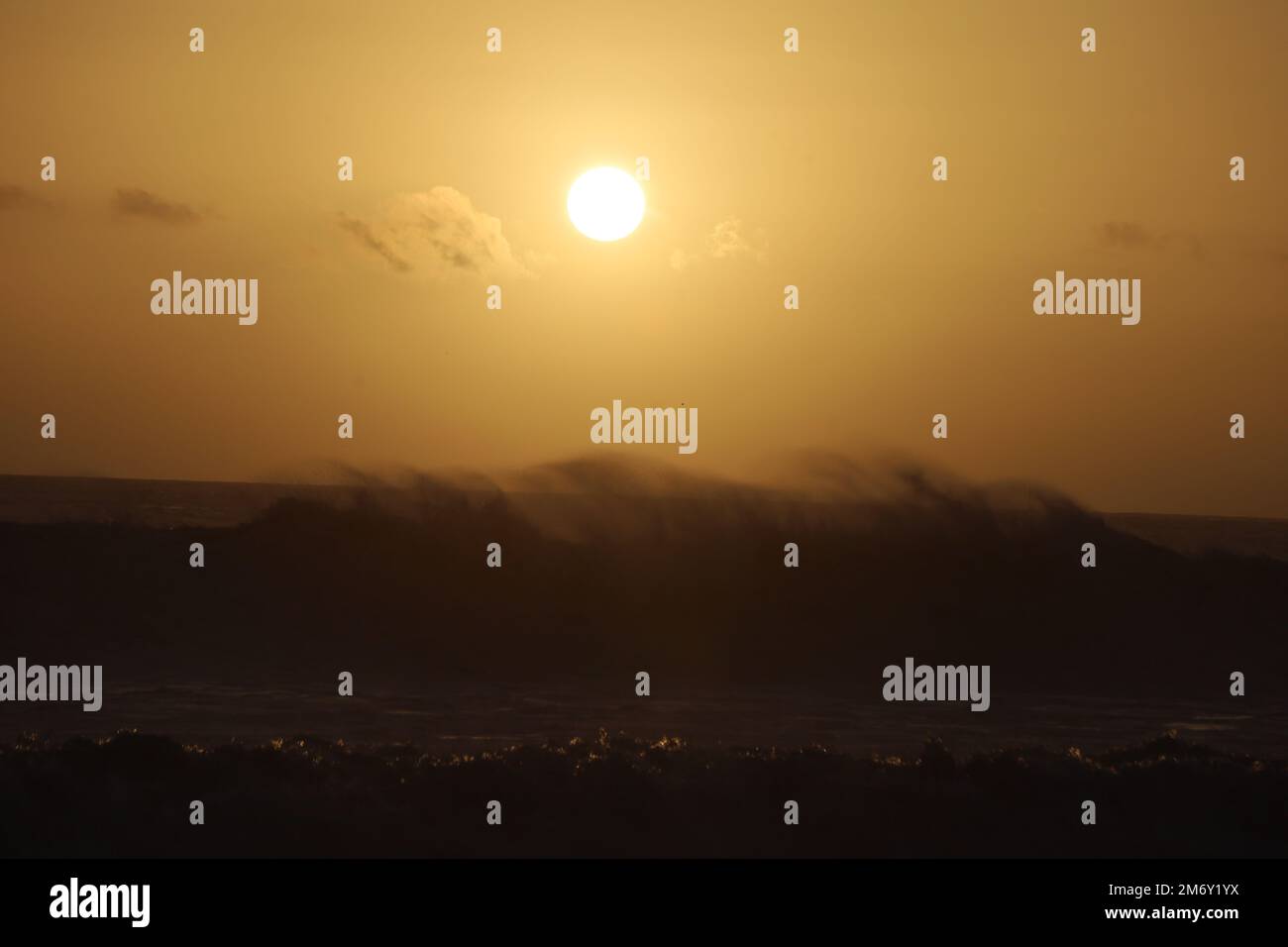 Montecito, California, U.S.A. 6th Jan, 2023. A yellow sunset over spectacular dark waves at Butterfly Beach, in front of the Four Season's Hotel in Montecito, California, near Santa Barbara, after a frightening storm caused evacuations. (Credit Image: © Amy Katz/ZUMA Press Wire) Stock Photo